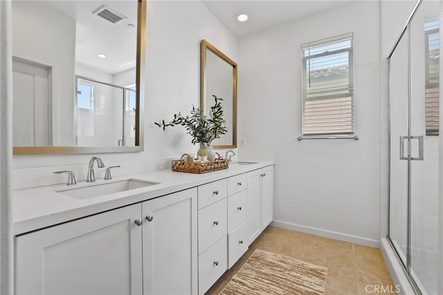 full bath featuring a sink, baseboards, a shower stall, and visible vents