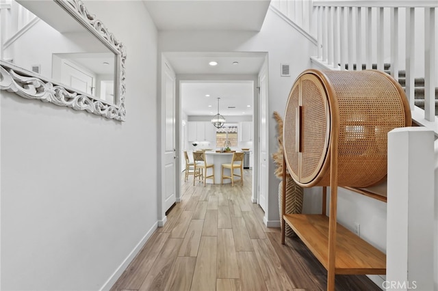 corridor with recessed lighting, baseboards, visible vents, and wood finished floors