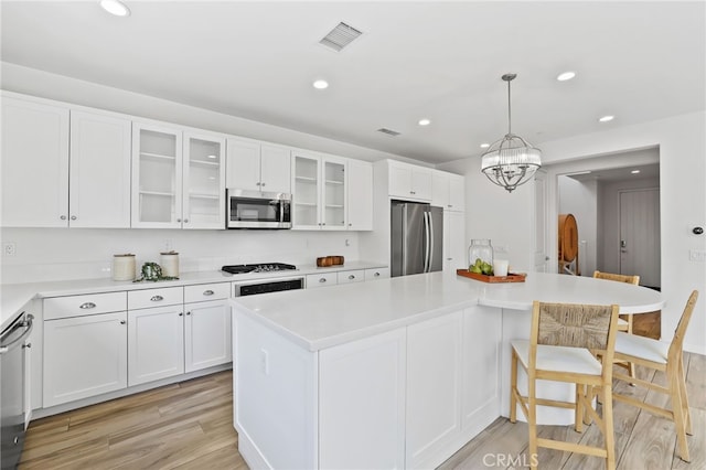 kitchen featuring light wood-type flooring, white cabinetry, and stainless steel appliances