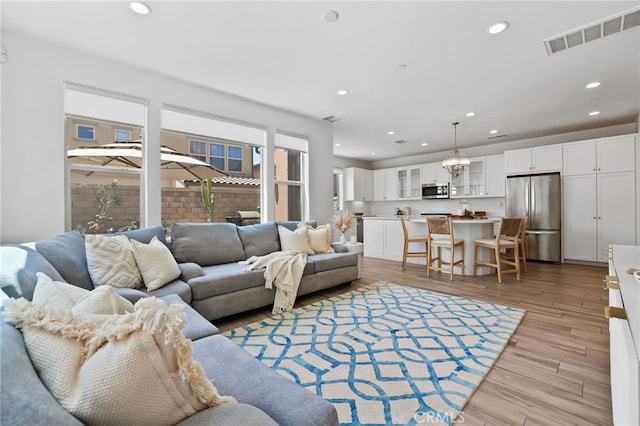 living area featuring visible vents, recessed lighting, and light wood-type flooring