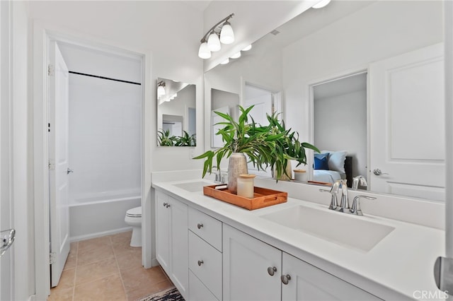 bathroom featuring double vanity, a sink, tile patterned flooring, and toilet