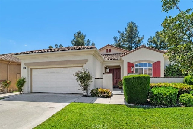 mediterranean / spanish home featuring an attached garage, stucco siding, and driveway