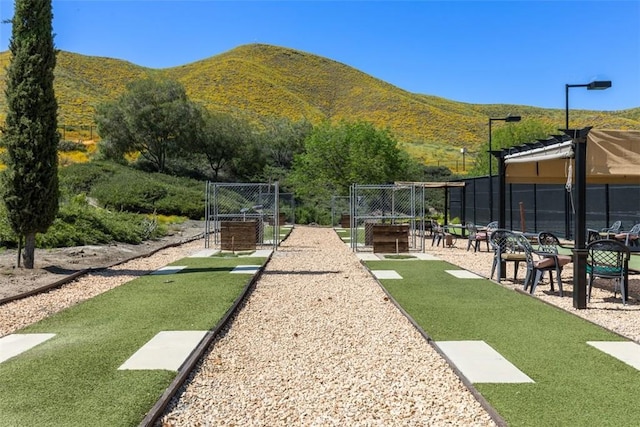 view of community with fence and a mountain view