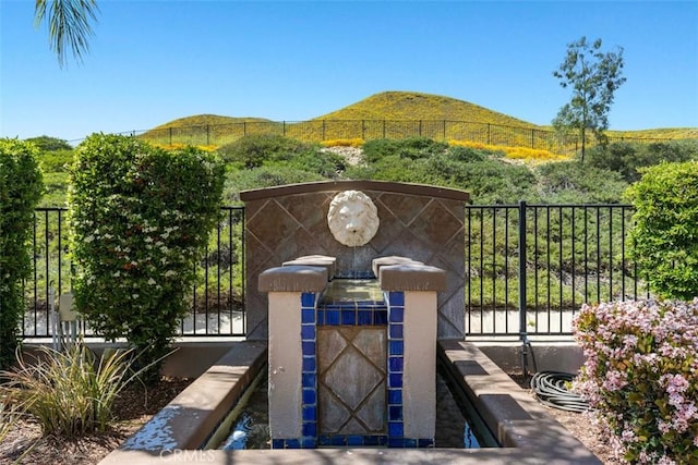 view of gate with fence and a mountain view