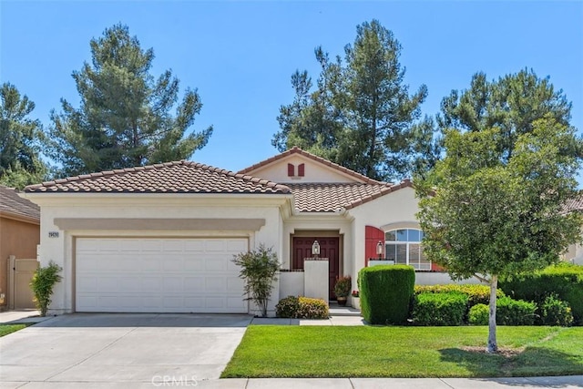 mediterranean / spanish house with a front yard, stucco siding, concrete driveway, an attached garage, and a tile roof