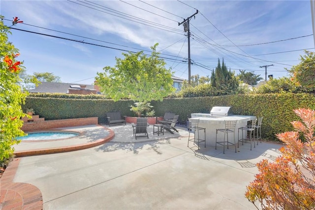 view of patio / terrace with a hot tub, fence, and outdoor dry bar