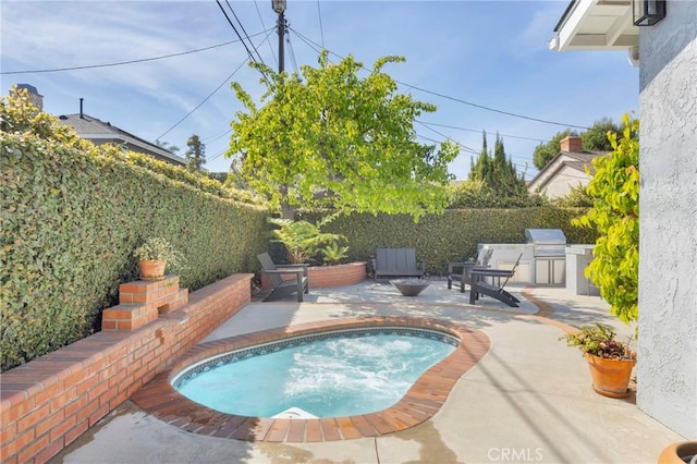 view of swimming pool featuring a patio area, exterior kitchen, grilling area, and fence
