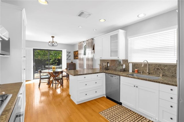 kitchen with stainless steel dishwasher, visible vents, a peninsula, white cabinets, and a sink