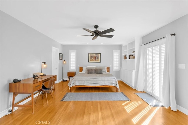 bedroom with baseboards, ceiling fan, and light wood-style floors
