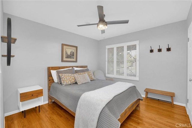 bedroom featuring baseboards, ceiling fan, and wood finished floors