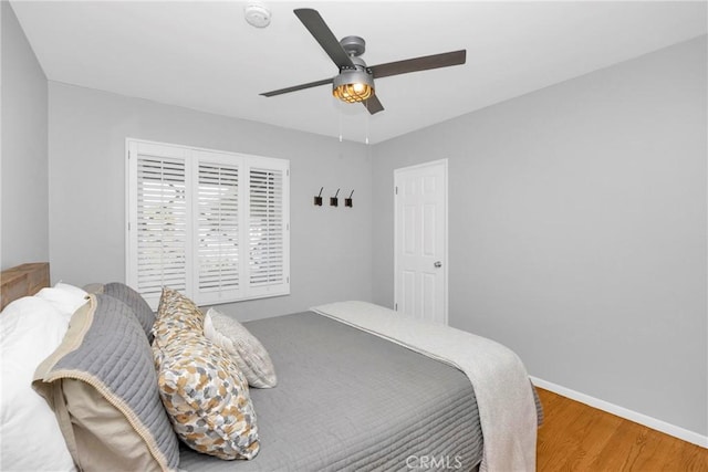 bedroom featuring baseboards, ceiling fan, and wood finished floors