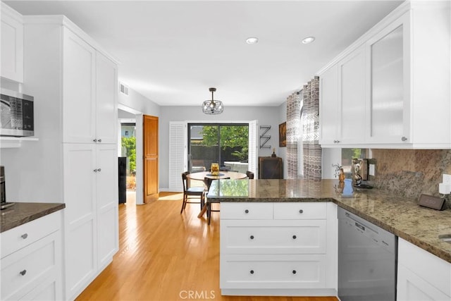 kitchen featuring a peninsula, white cabinets, and stainless steel appliances