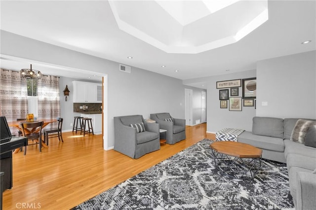 living room featuring a chandelier, recessed lighting, light wood-style flooring, and visible vents
