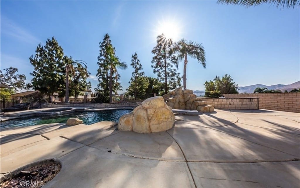 view of pool featuring a mountain view, a pool with connected hot tub, and a patio