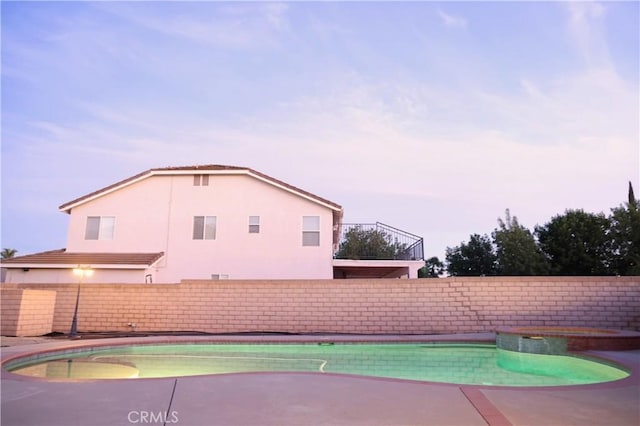 view of pool with a fenced backyard and a pool with connected hot tub