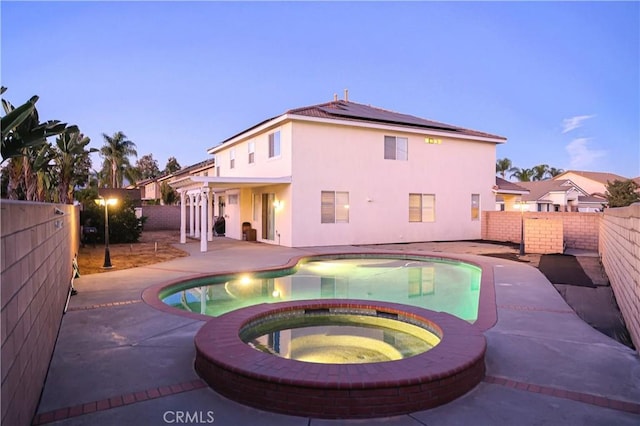 view of swimming pool featuring an in ground hot tub, a fenced in pool, a fenced backyard, and a patio area