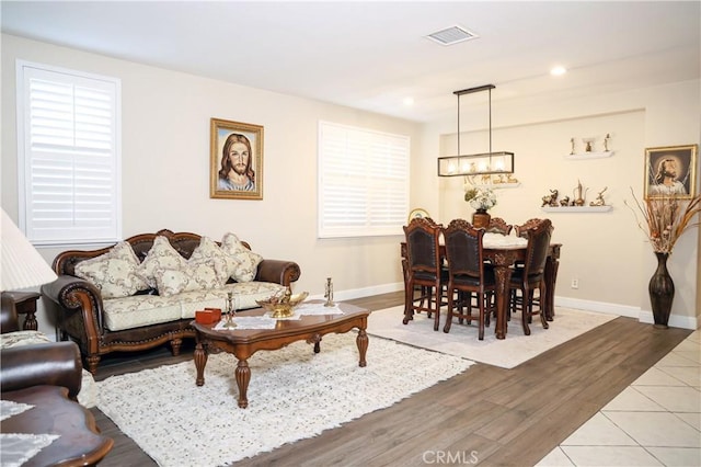 living room featuring a notable chandelier, recessed lighting, baseboards, wood finished floors, and visible vents