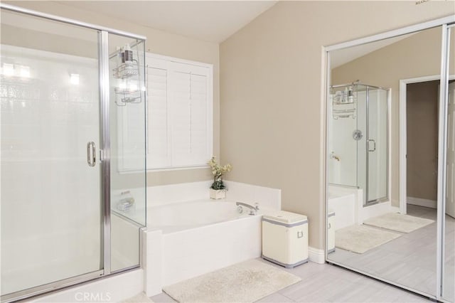 bathroom with tile patterned floors, a shower stall, and a bath