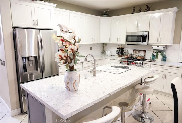 kitchen featuring white cabinets, light tile patterned flooring, and stainless steel appliances