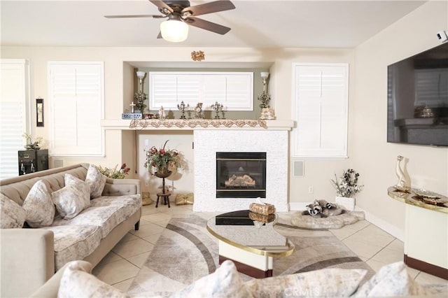 tiled living room featuring ceiling fan and a fireplace