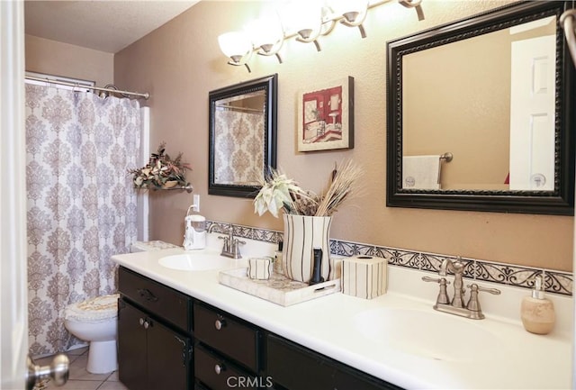 bathroom with double vanity, toilet, a sink, and tile patterned floors