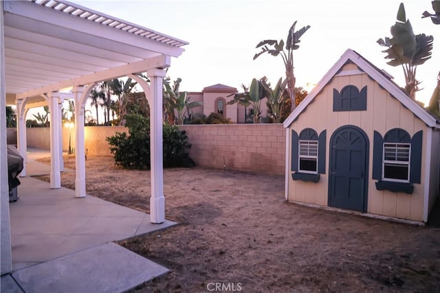 view of yard featuring a fenced backyard, a pergola, an outdoor structure, and a patio