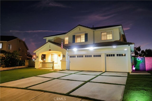 view of front of house with a garage, stucco siding, and driveway