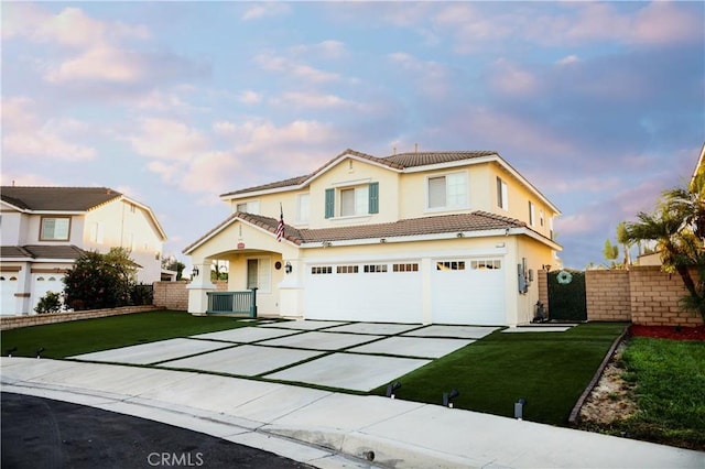 traditional home featuring fence, an attached garage, a tile roof, a yard, and driveway