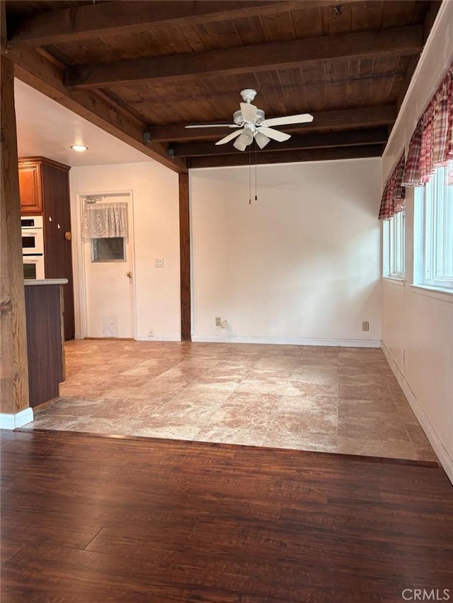 empty room with wood ceiling, beamed ceiling, and a ceiling fan