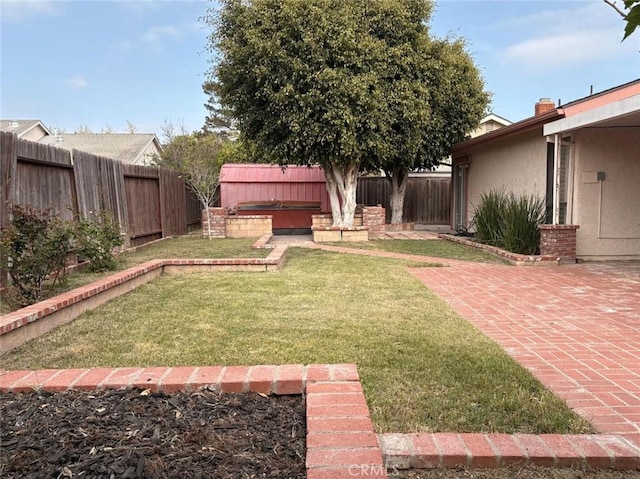 view of yard with a patio, a fenced backyard, and a hot tub
