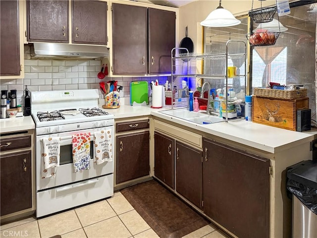 26731 Greenvale Way, Desert Center, CA 92239 - kitchen featuring white range with gas cooktop, a sink, under cabinet range hood, light tile patterned floors, and light countertops
