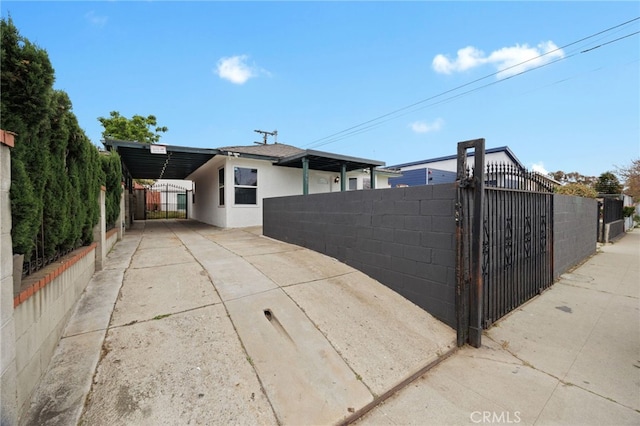 11867 S San Pedro St, Los Angeles, CA 90061 - exterior space featuring concrete driveway, a gate, fence private yard, and stucco siding