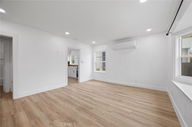 11867 S San Pedro St, Los Angeles, CA 90061 - empty room with recessed lighting, a wall mounted AC, and light wood-style flooring