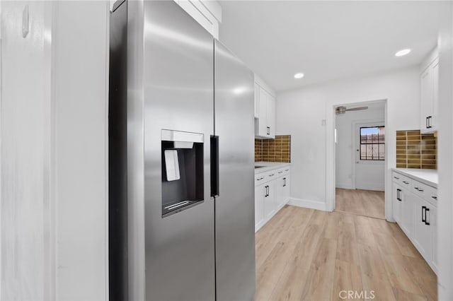 11867 S San Pedro St, Los Angeles, CA 90061 - kitchen featuring stainless steel refrigerator with ice dispenser, light countertops, white cabinetry, and backsplash