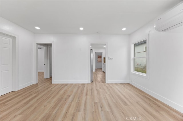 11867 S San Pedro St, Los Angeles, CA 90061 - unfurnished bedroom with recessed lighting, a wall mounted air conditioner, light wood-style flooring, and baseboards