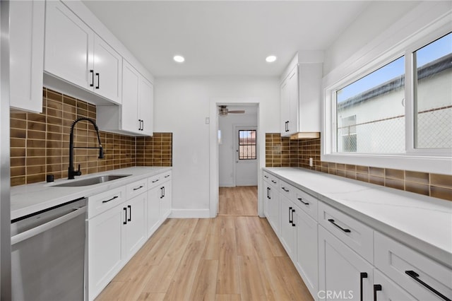 11867 S San Pedro St, Los Angeles, CA 90061 - kitchen with white cabinetry, tasteful backsplash, a sink, light wood-style flooring, and dishwasher