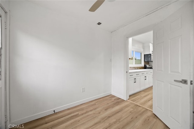 11867 S San Pedro St, Los Angeles, CA 90061 - empty room with baseboards, light wood finished floors, and ceiling fan