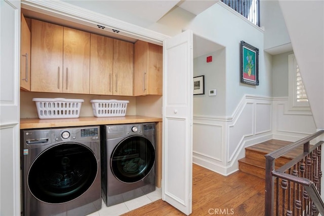 617 Crest Dr, Manhattan Beach, CA 90266 - laundry area featuring washing machine and clothes dryer, cabinet space, a wainscoted wall, light wood-type flooring, and healthy amount of natural light