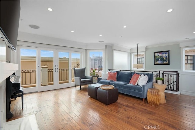 living area featuring crown molding, recessed lighting, and hardwood / wood-style flooring