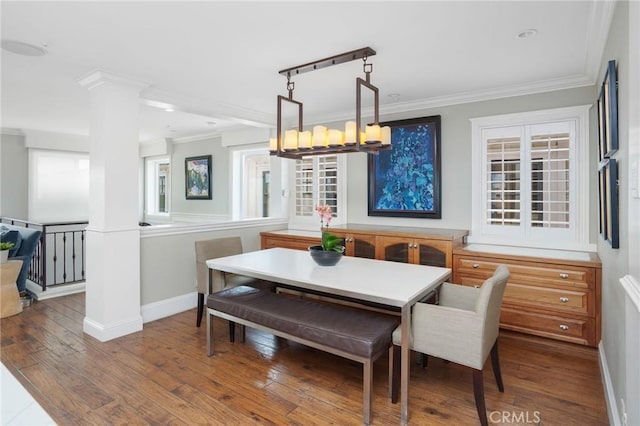 dining area with crown molding, baseboards, a chandelier, and wood-type flooring