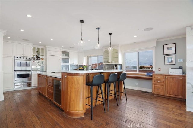 617 Crest Dr, Manhattan Beach, CA 90266 - kitchen with stainless steel double oven, open shelves, beverage cooler, ornamental molding, and a warming drawer