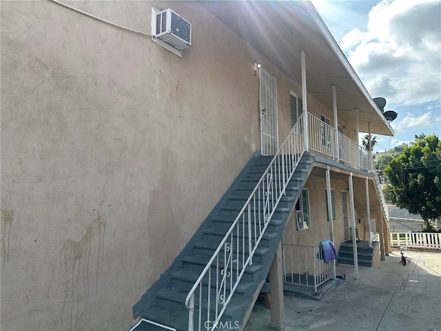 view of home's exterior with stairs and stucco siding