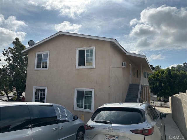 view of home's exterior with stucco siding and fence