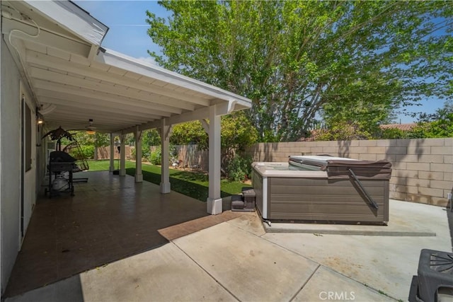 view of patio / terrace with a fenced backyard, a hot tub, and a grill