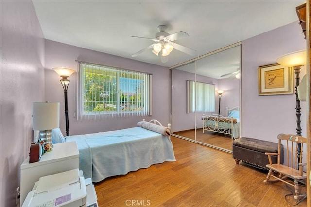 bedroom with a closet, a ceiling fan, and wood finished floors