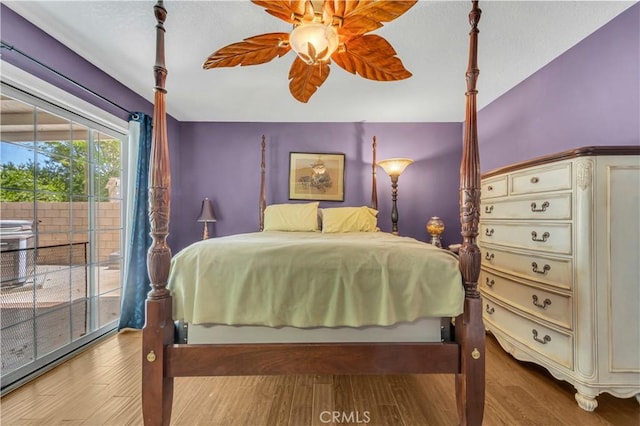bedroom featuring a ceiling fan, wood finished floors, and access to exterior