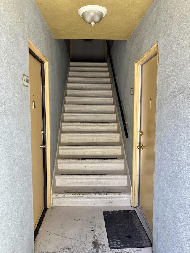 stairs featuring a textured wall