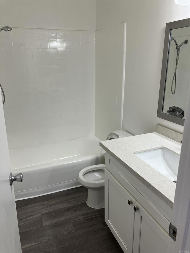 bathroom featuring shower / bathtub combination, toilet, wood finished floors, and vanity
