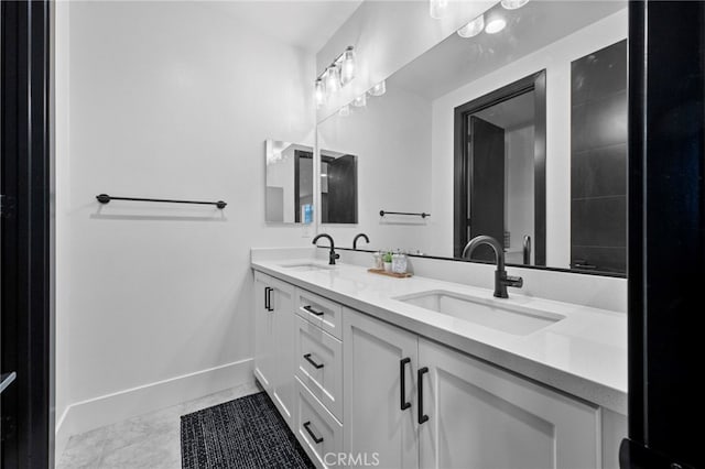 bathroom with baseboards, a sink, and double vanity