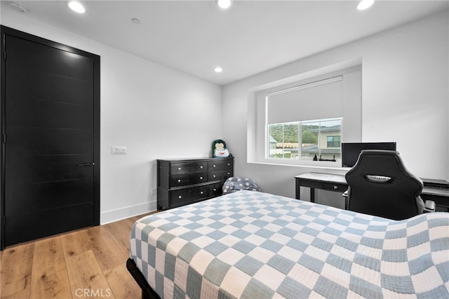 bedroom with recessed lighting, baseboards, and wood finished floors